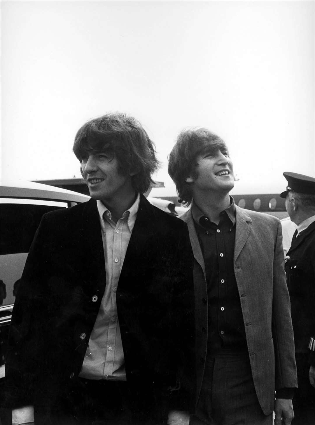 George Harrison and John Lennon depart London Airport in 1965 (PA)