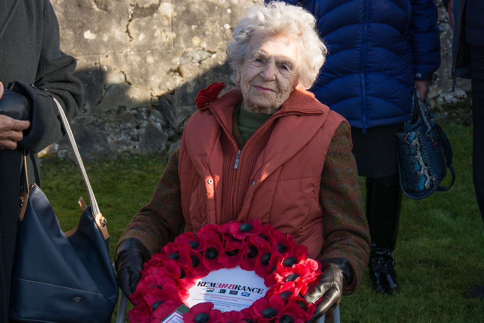 Isobel Harling holding a wreath at commemorations in Kingussie's new cemetery in 2019.