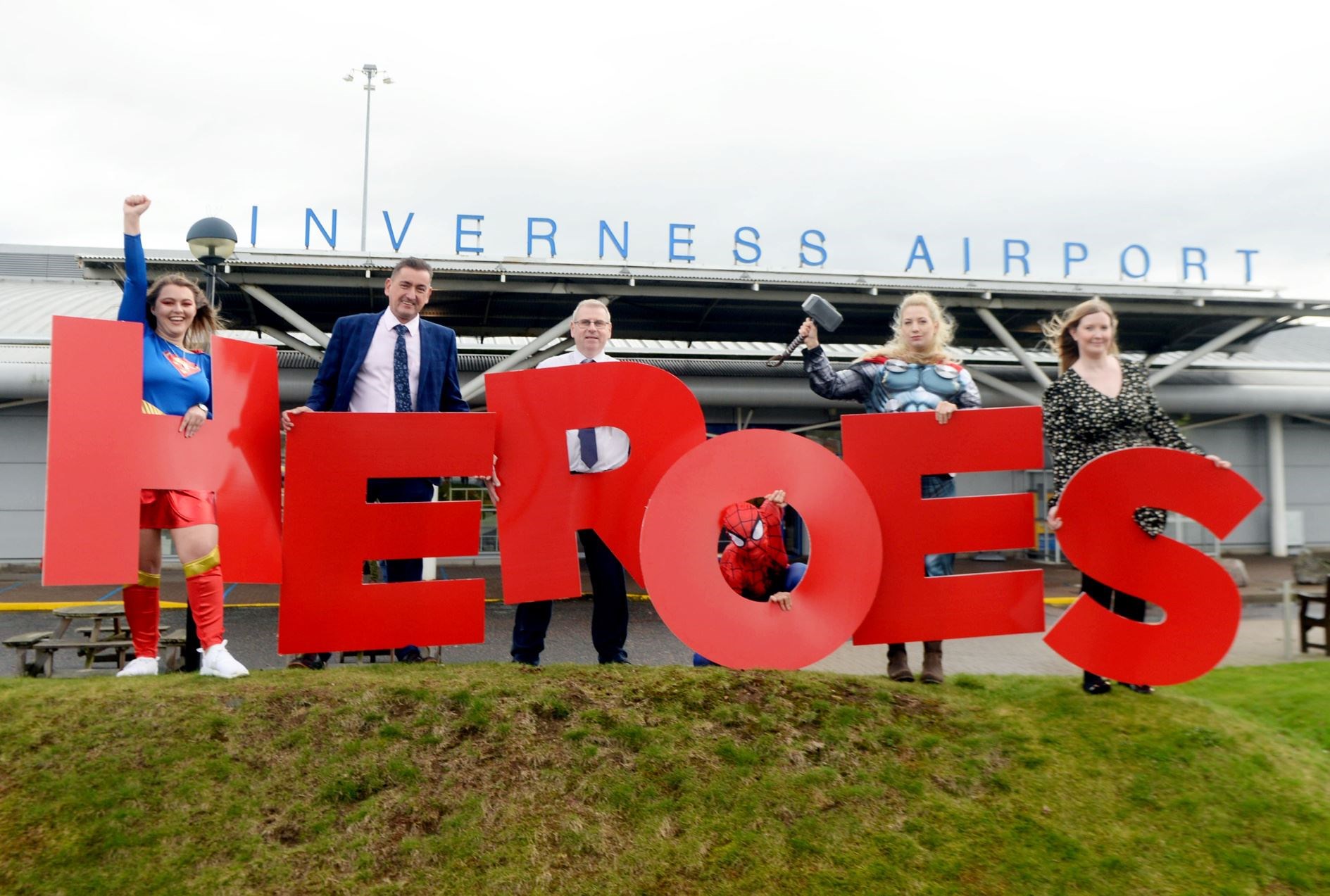 Graeme Bell, Inverness Airport general manager, Davie Geddes, terminal operations manager and Cheryl Campbell, airport services manager – with some super friends – launched Highland Heroes 2022. Picture: James Mackenzie.