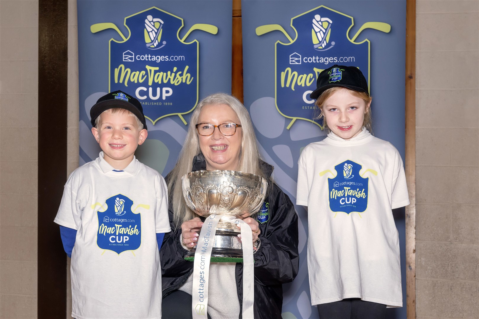 Hamish Robinson and Marnie MacKintosh either side of Janette Macdonald of cottages.com following the first round draw at Newtonmore Primary School. Picture: Neil G Paterson.