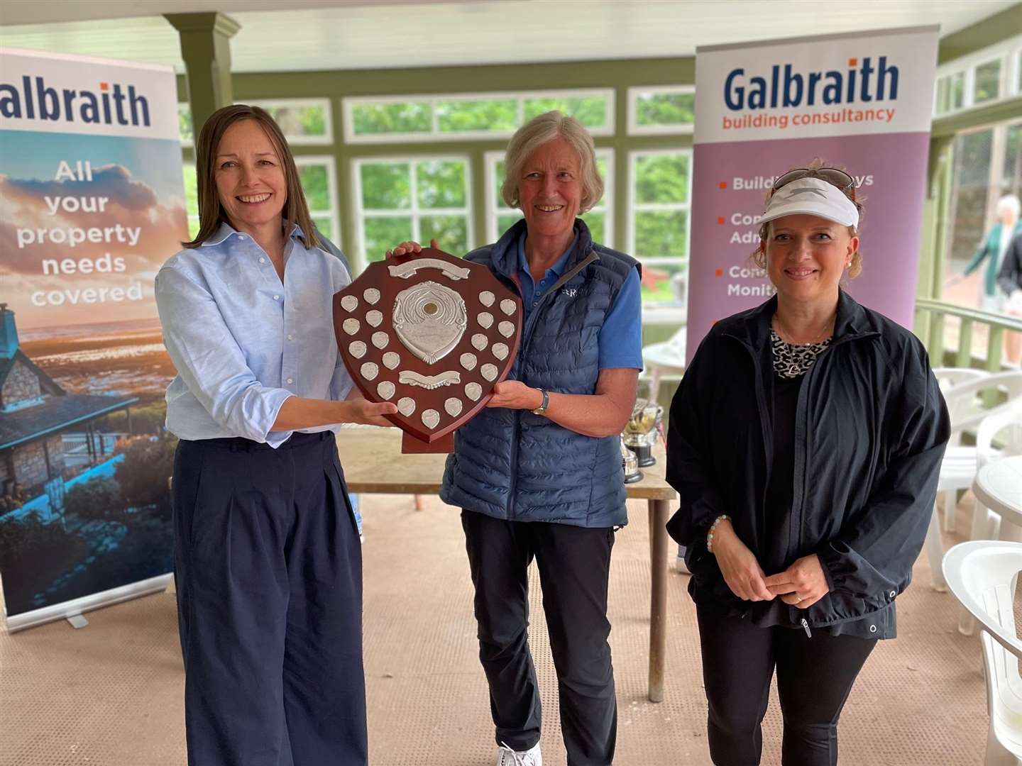 Phiddy Robertson hands over the shield to R&A Tennis Club's Judith Marten (centre) and Kim Beattie (right).