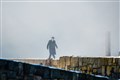 Tommy Shelby, who is played by Cillian Murphy, walks along Portsoy's old harbour pier through artificial smoke during filming. Picture: Daniel Forsyth