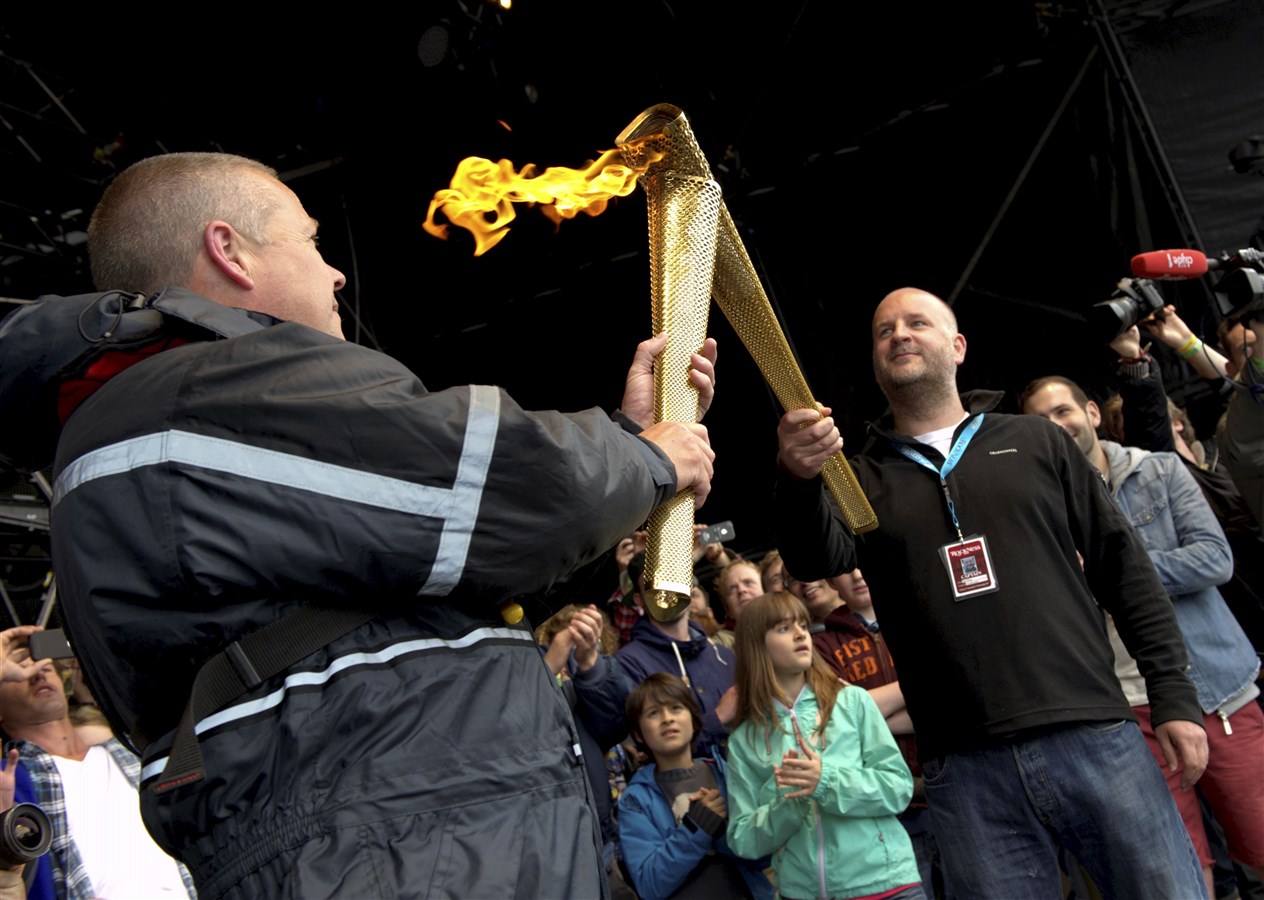 Rockness 2012 ex police chief inspector Blair Marquis handed over the Olympic torch to one of the RockNess promoters Jim King on stage. Picture: HNM/ Callum Mackay