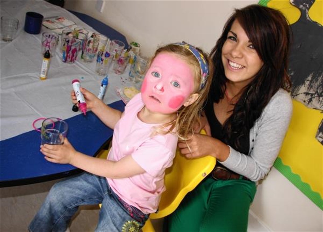 Staff member Sionainn Carmichael helps Maria Langran with her glass painting