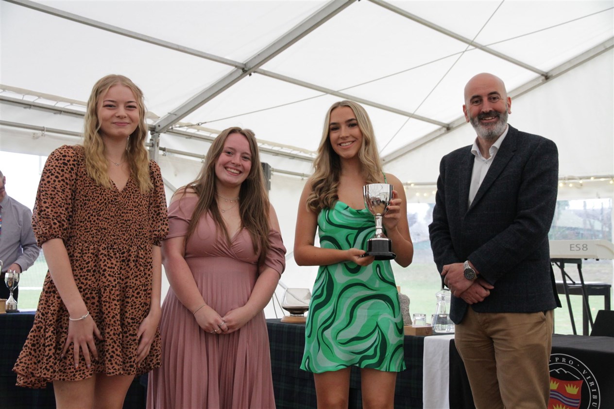 HOUSE WINNERS CUP: Amber Beange, Christie Rose and Morven Rose collected the trophy for Roy from Ewen Mackintosh.