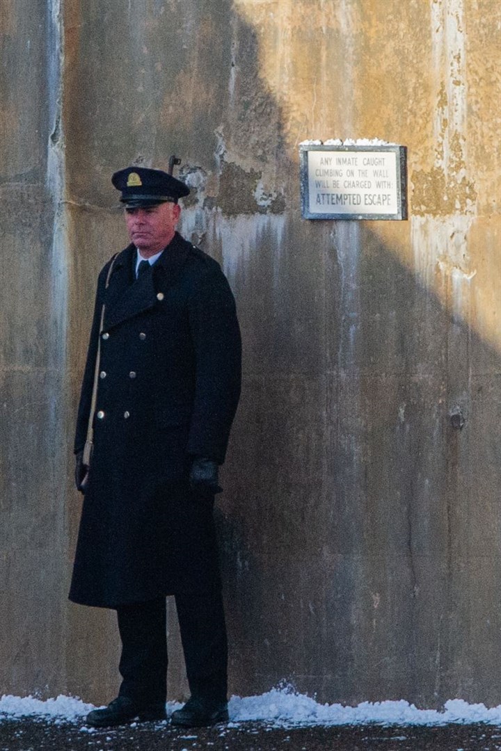 A guard stands next to a plaque 'Any inmate caught climbing on the walls will be charged with attempted escape', suggesting the scene filmed was a prison scene. ..Picture: Daniel Forsyth..