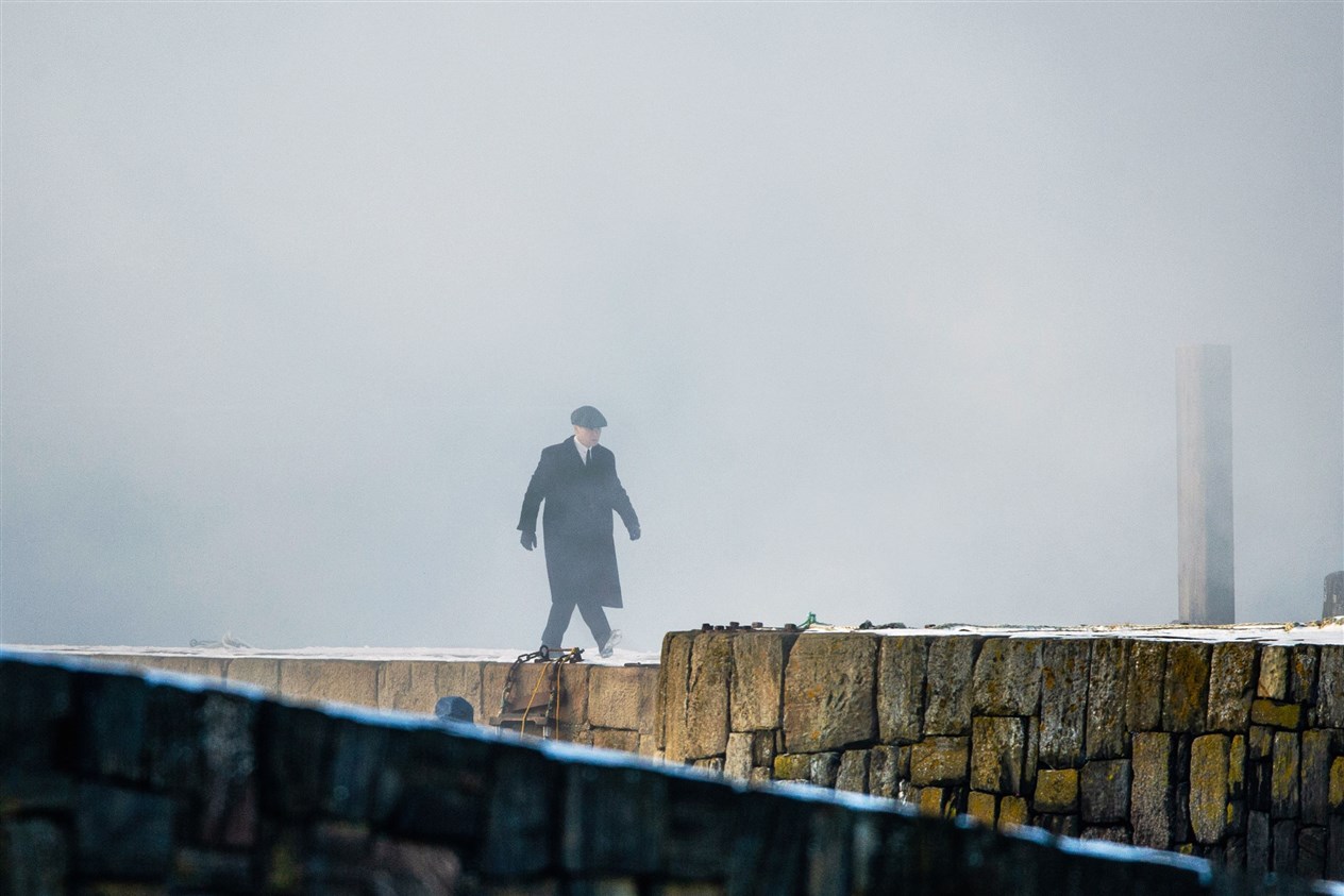 Tommy Shelby, who is played by Cillian Murphy, walks along Portsoy's old harbour pier through artificial smoke during filming. Picture: Daniel Forsyth