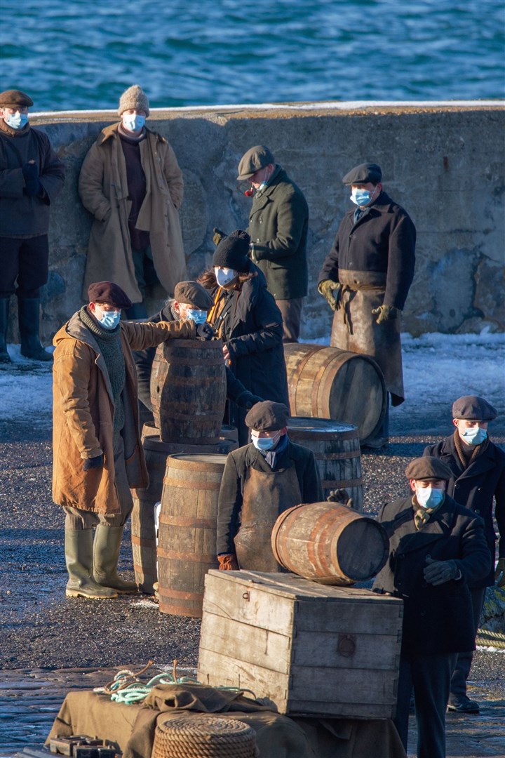 Extras wear Covid masks during a break in filming at Portsoy in February 2021. Picture: Daniel Forsyth