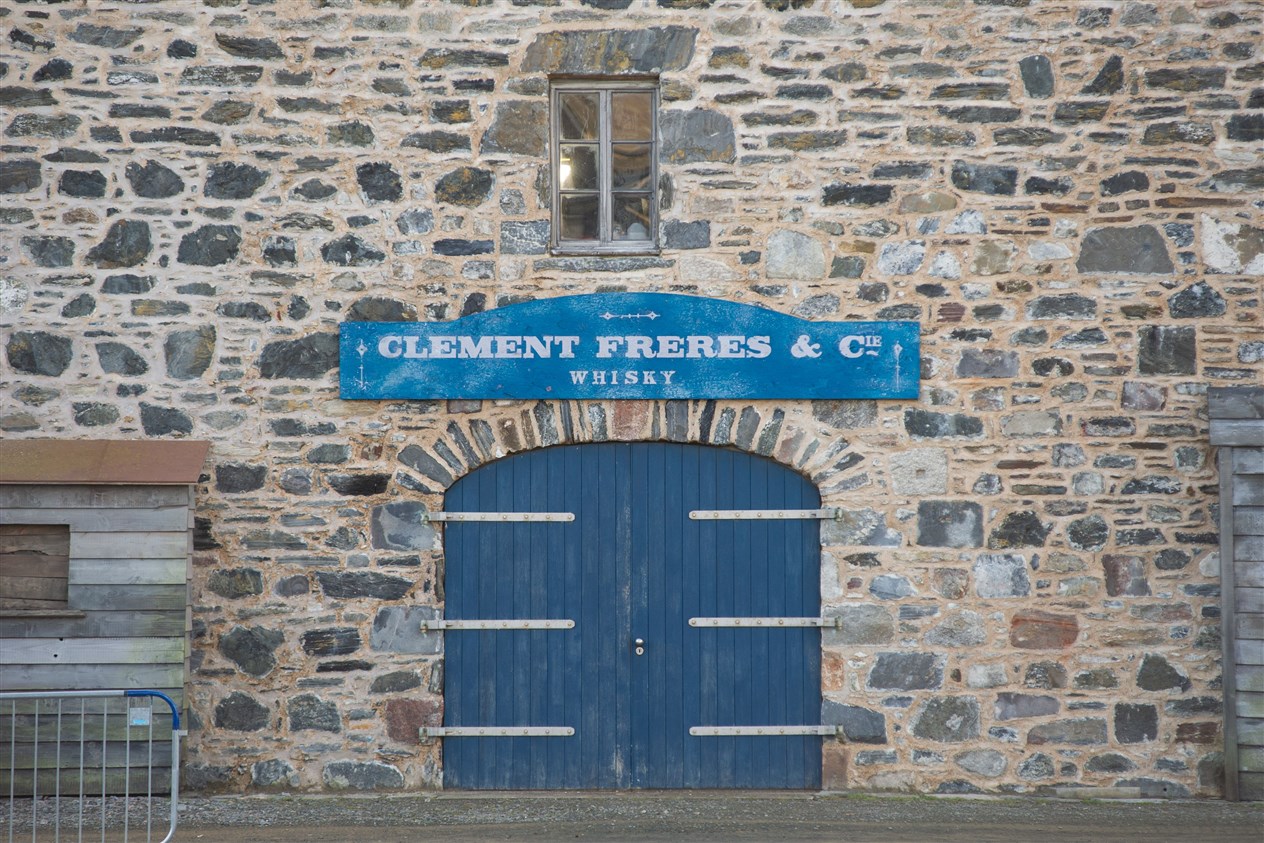 A French sign 'Clement Freres & Cie - Whisky' was placed on this harbour facing building with wooden shed added to the exterior also. Picture: Daniel Forsyth