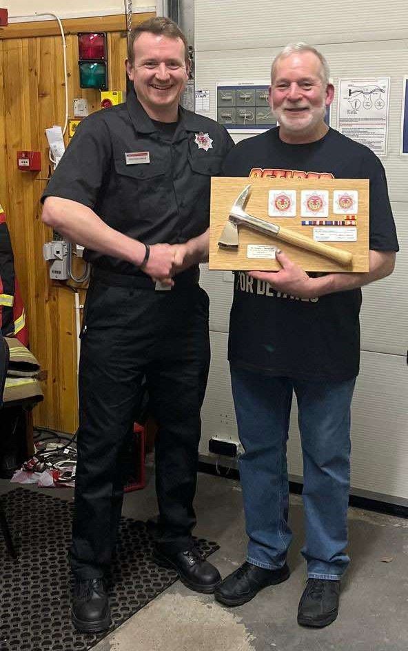 Dougie Macdonald (right) is presented with his ceremonial fire axe from nephew Ross Macdonald, who keeps the family flag flying at Carrbridge.