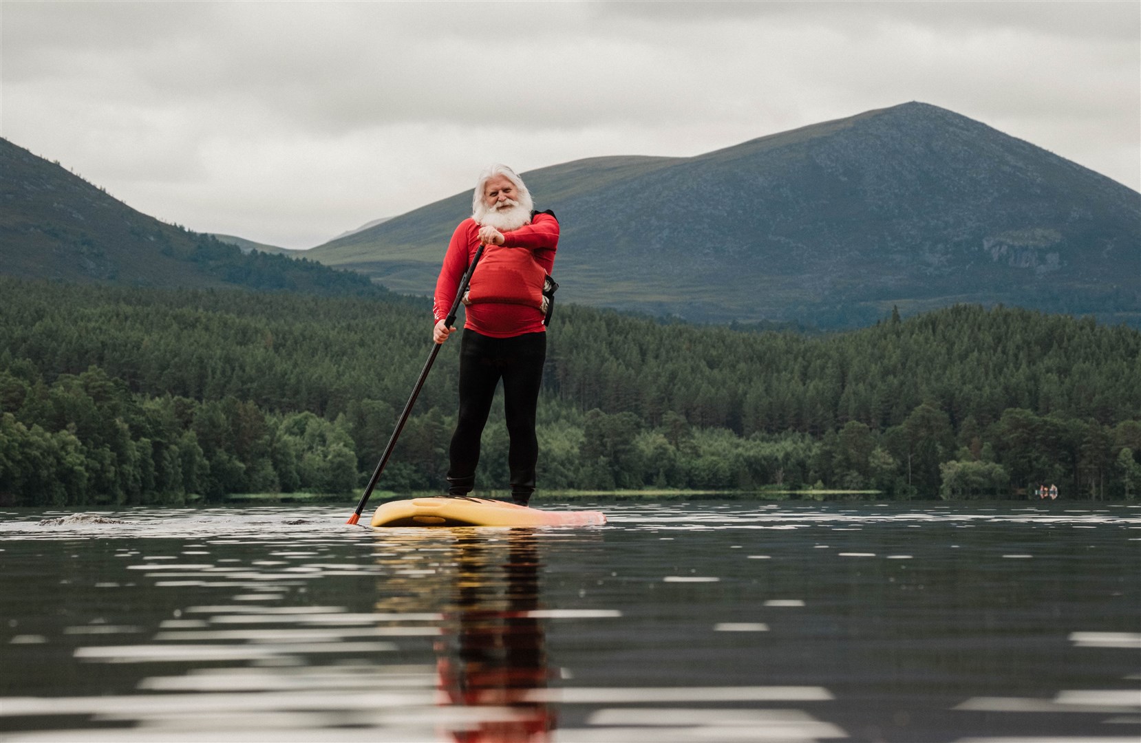 Santa paddleboarding in Loch Morlich as part of his holiday.