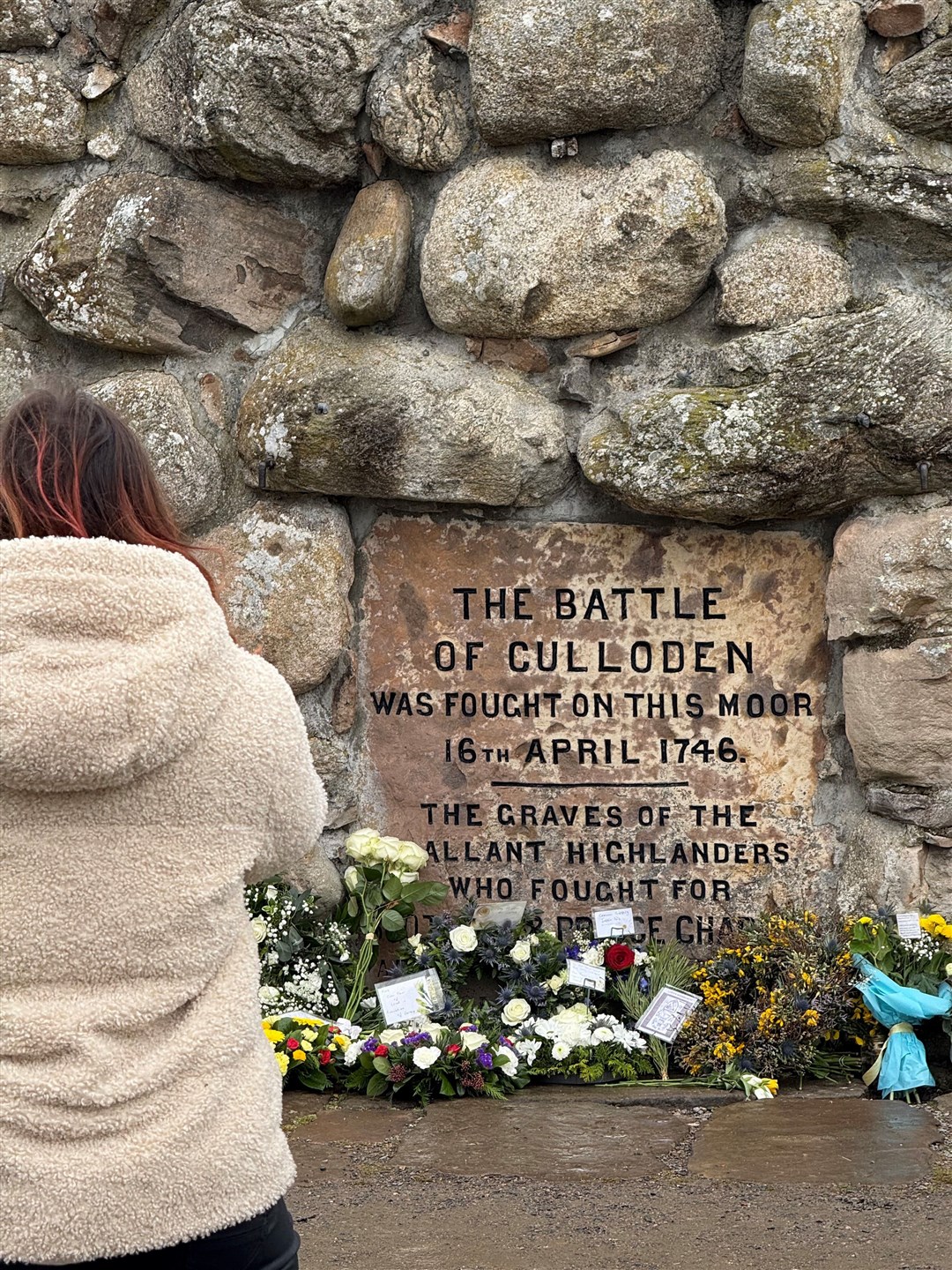 Onlookers at the memorial cairn following the service.