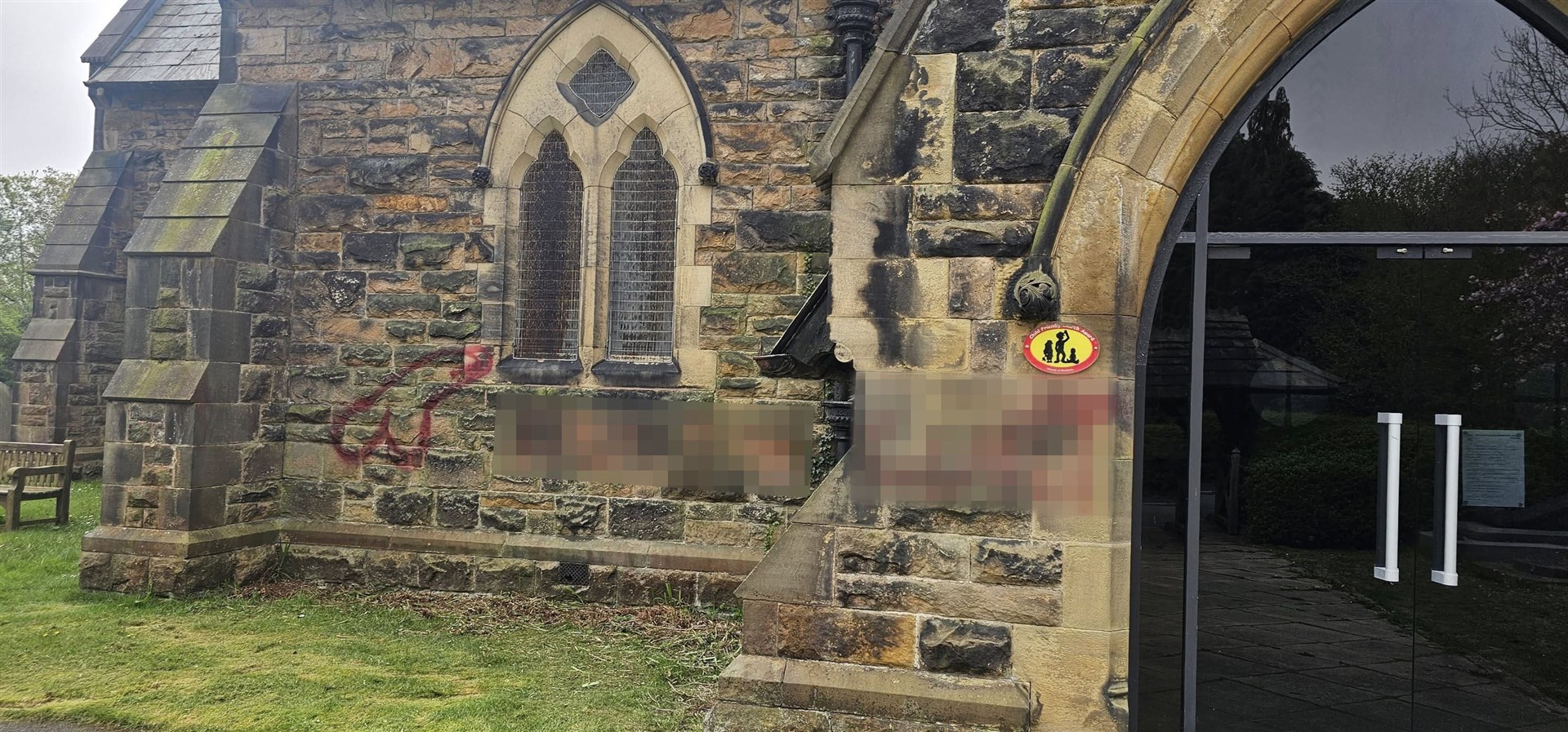 Pixelated image of the offensive phrases daubed in red paint near the door of the church (Paul Wharton-Hardman/PA)
