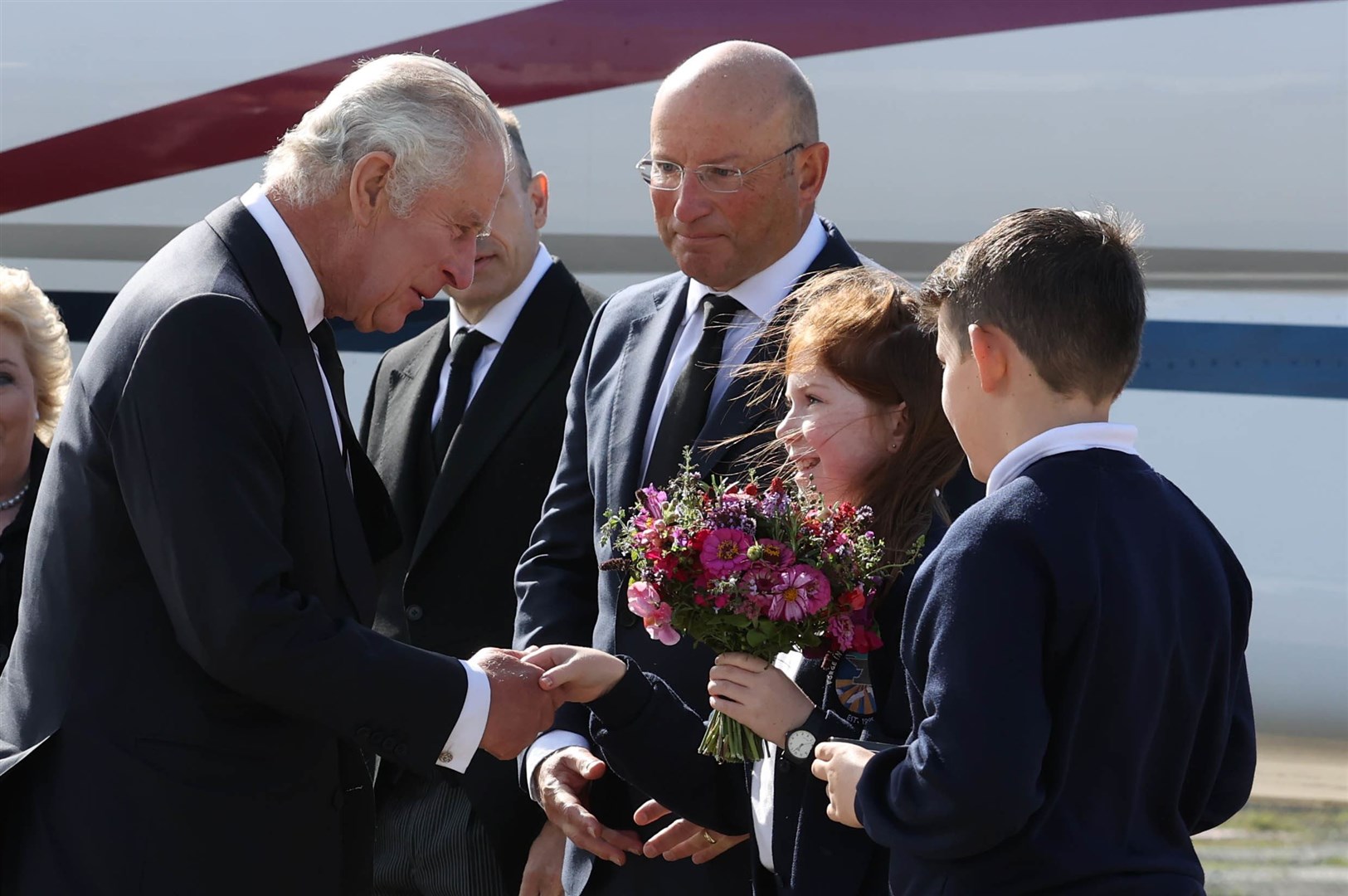The King was greeted by Ella Smith and Lucas Watt, both 10, as he arrived at George Best Belfast City Airport (Liam McBurney/PA)