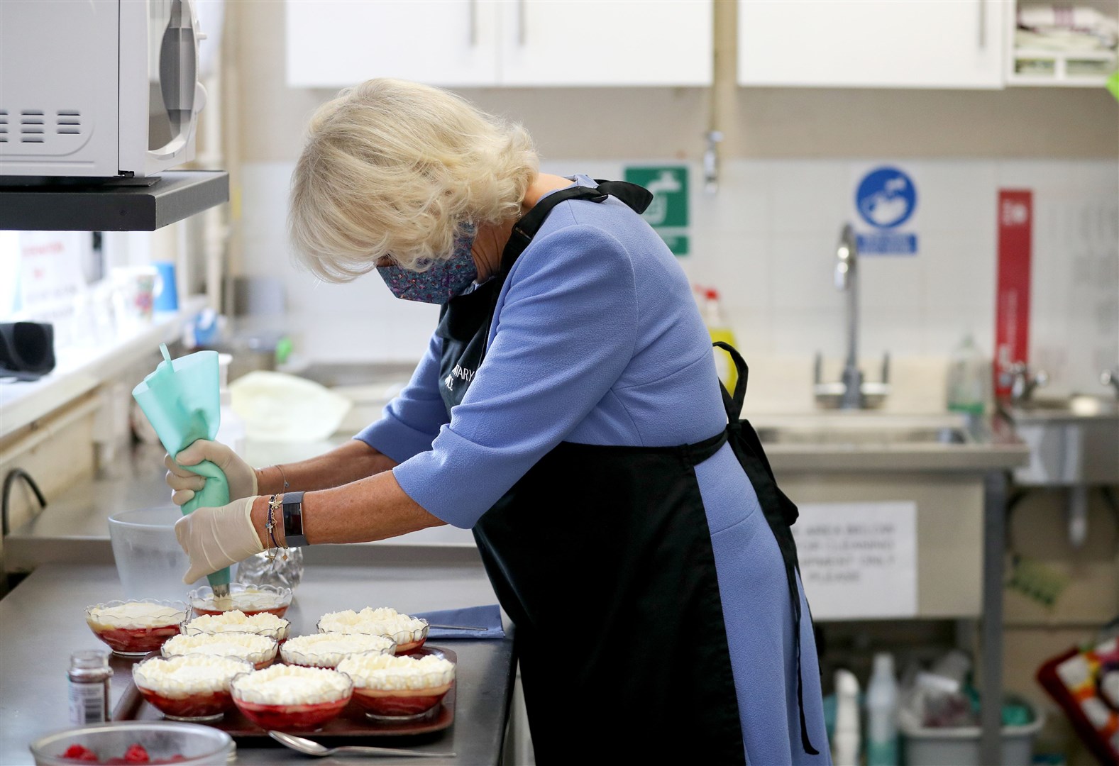 Camilla stayed on to help decorate trifle puddings (Andrew Matthews/PA)