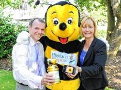 Andrew Leaver, director of fundraising, retail and communications at Highland Hospice, and SPP's managing director Thelma Henderson launching Hospice Lucky Numbers with the help of the hospice mascot, Bobby the Bee.