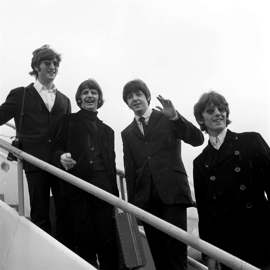 The Beatles board a plane in 1966 (PA)