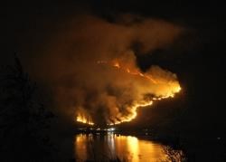 A wildfire burns in Kintail across Loch Duich