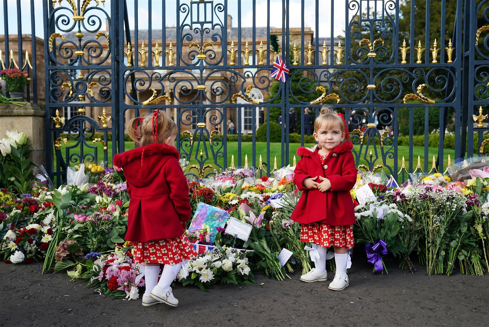 Twins Abigail and Arabella Glen, aged two, from Lisburn, at the gates of Hillsborough Castle, Co Down (Brain Lawless/PA)