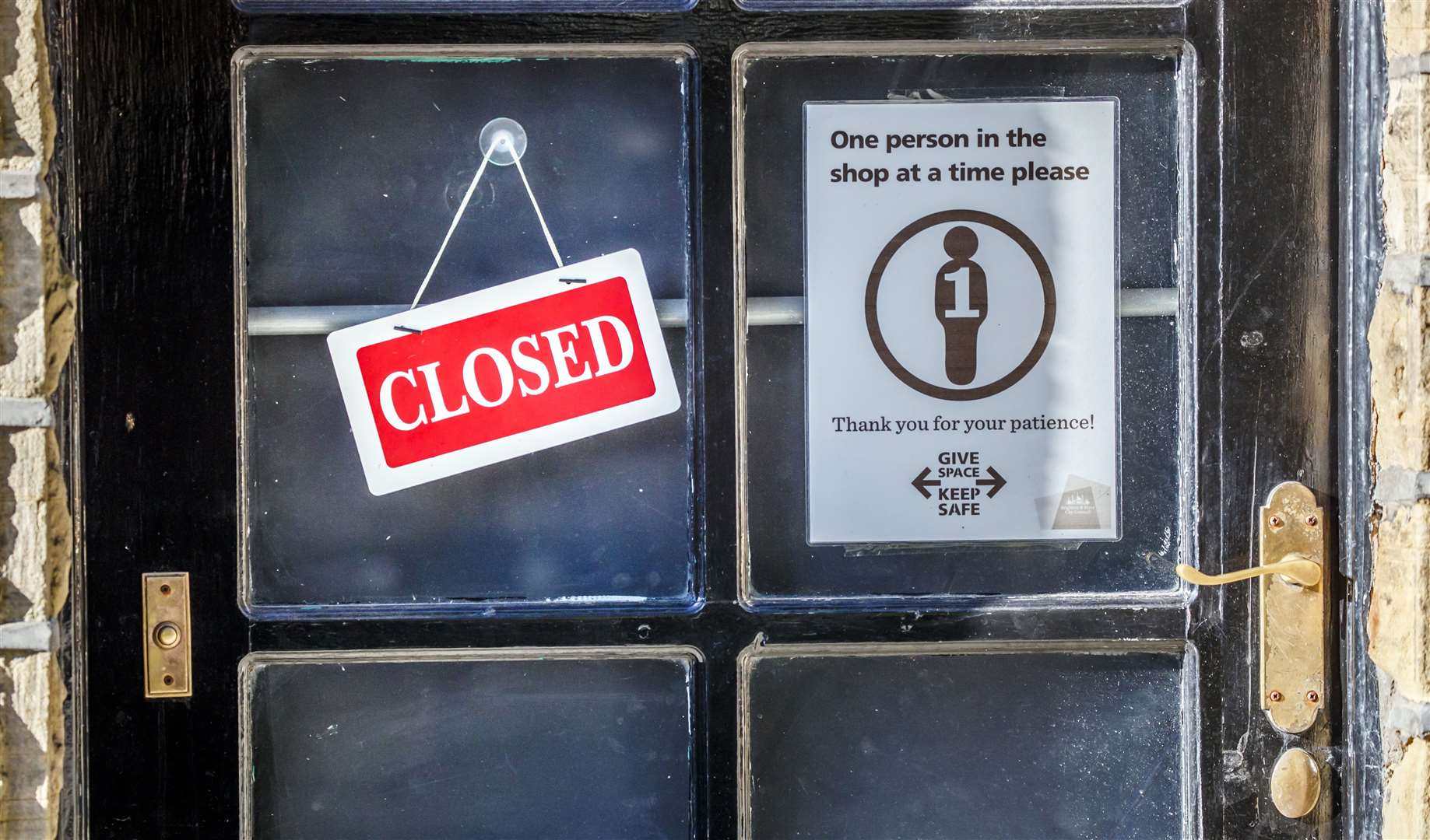 A closed sign next to a social distancing sign in a shop window in Haworth, West Yorkshire (Danny Lawson/PA)