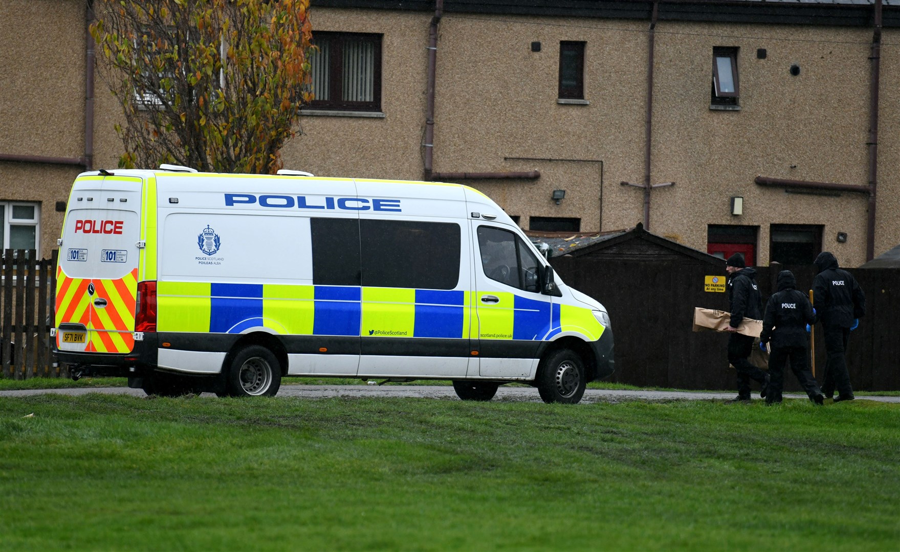 Police officers with items in evidence bags.