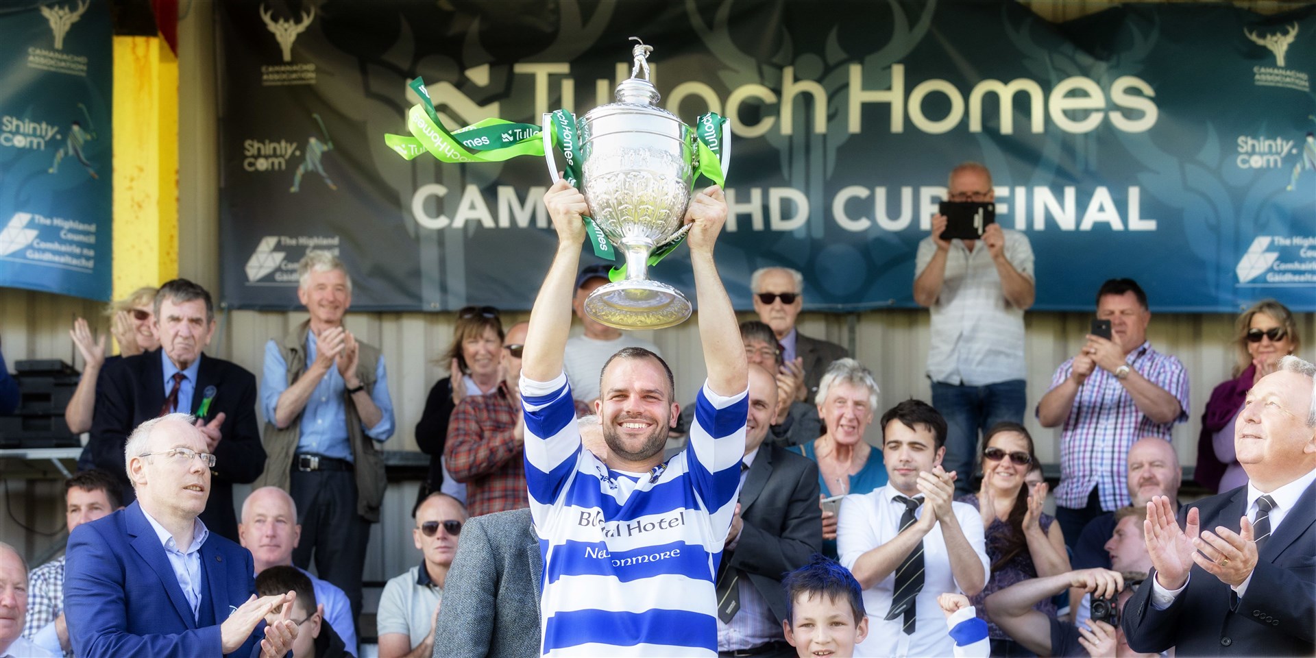 Newtonmore captain Evan Menzies lifts the Camanachd Cup in 2019 at An Aird, Fort William.