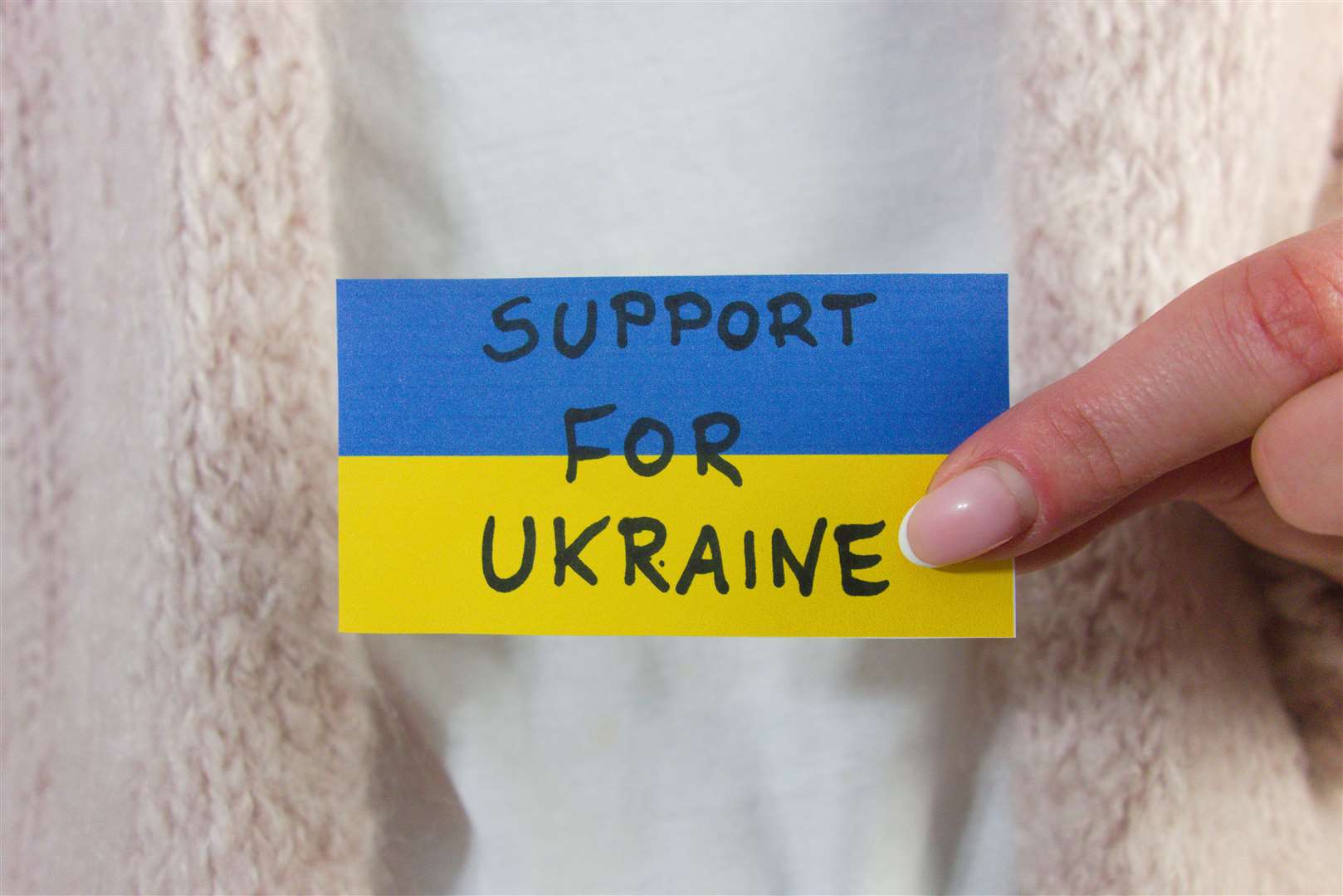 Woman holding Ukrainian flag with text stand for Ukraine.  Military aggression concept