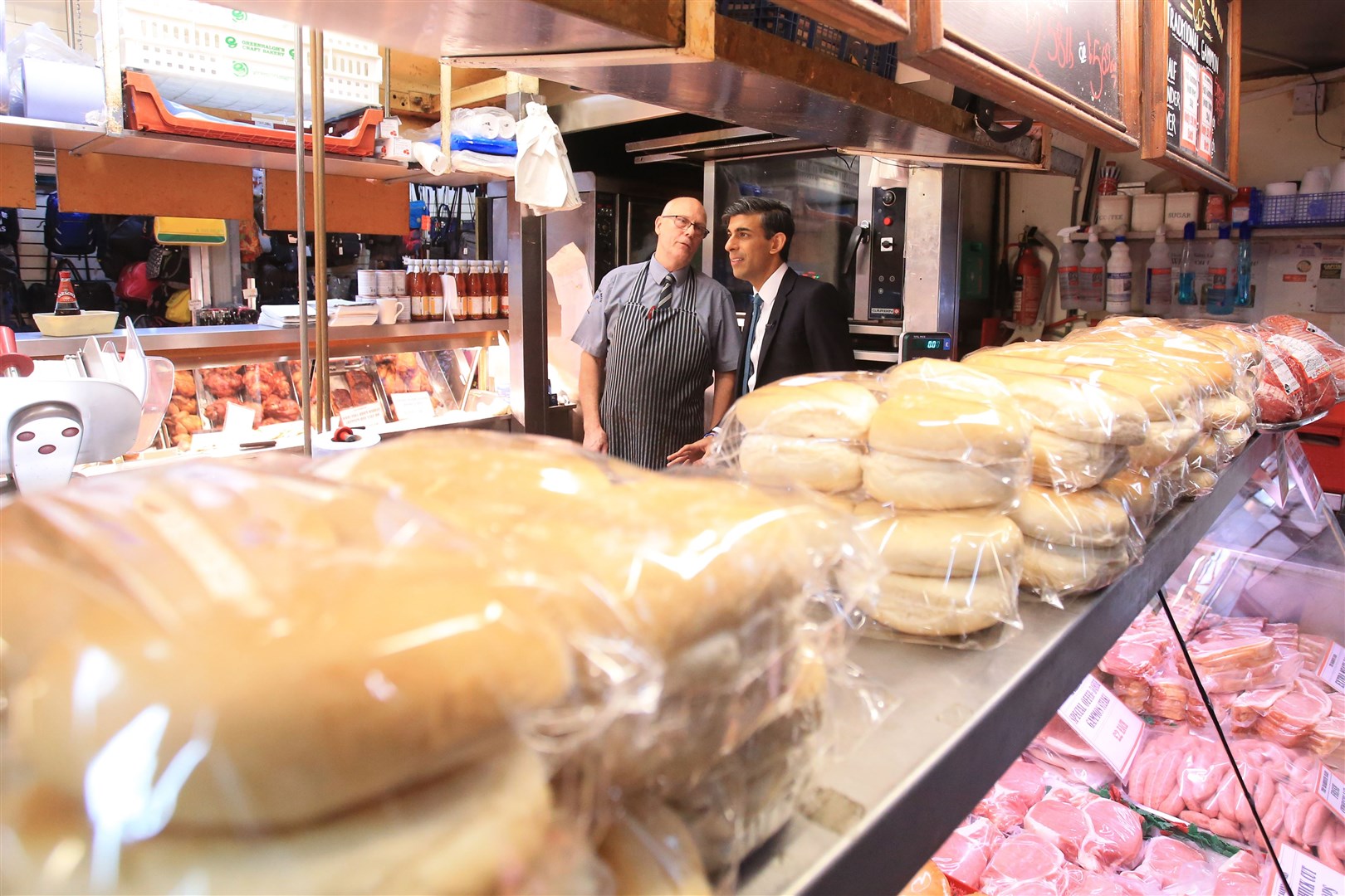 Rishi Sunak speaks to a butcher at Bury market (Lindsey Parnaby/PA)