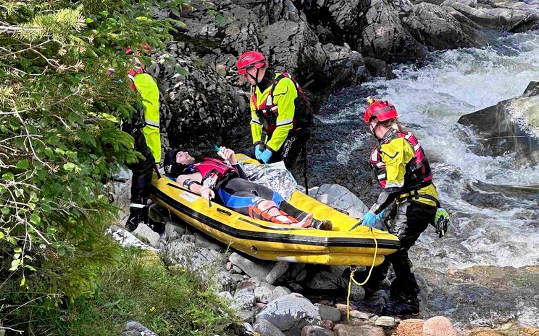 Mr Hamilton is carried from the waters of the River Feshie by rescuers.