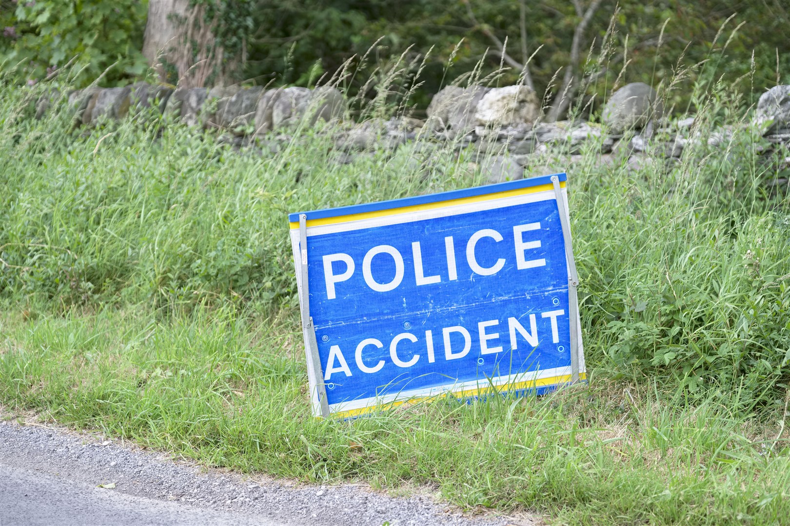 Police accident sign at road crash in rural countryside blind bend