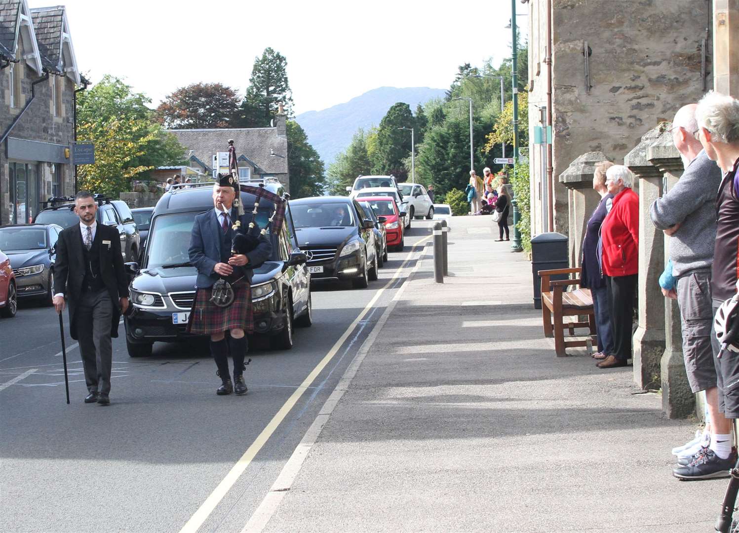 Piper Sandy MacDonell leads the cortege through Kingussie yesterday