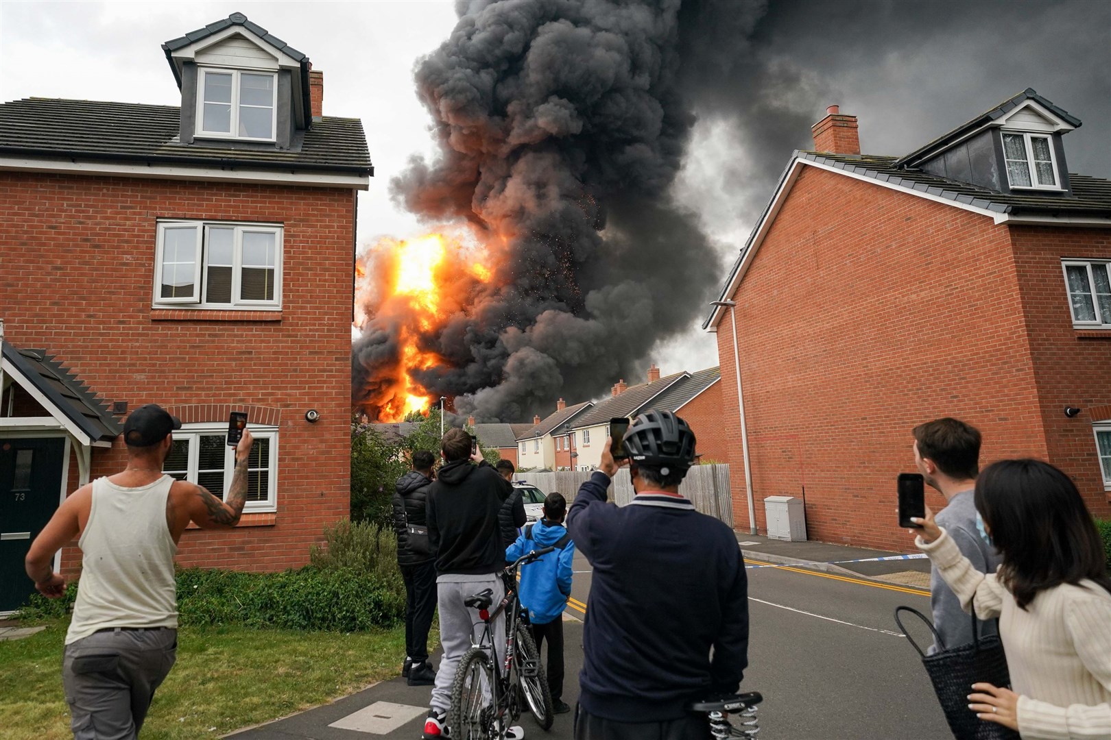 Residents watch an explosion during the fire (Jacob King/PA)