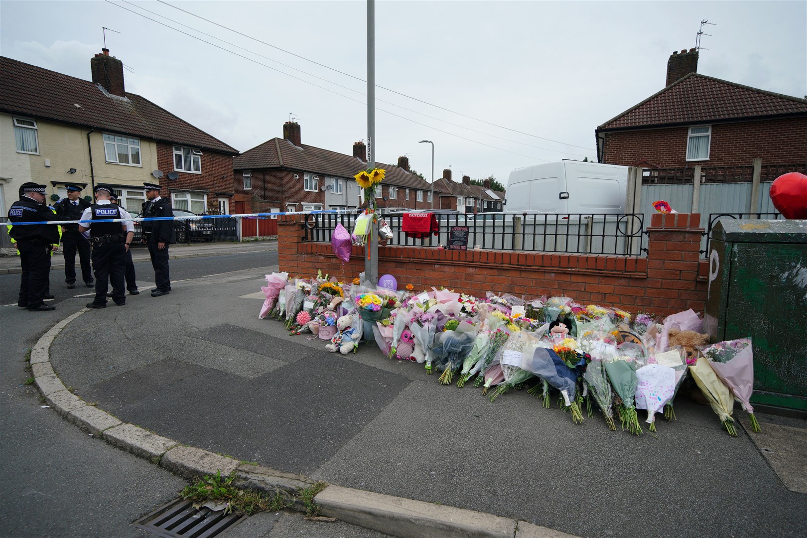 Flowers are left near to the scene in Kingsheath Avenue (Peter Byrne/PA)
