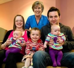 Community midwife Effie Rowan who lives on the Black Isle (back, centre) is pictured with mum Claire Chambers holding six-month-old Hannah, big brother Liam and dad Andrew McPhee holding Holly