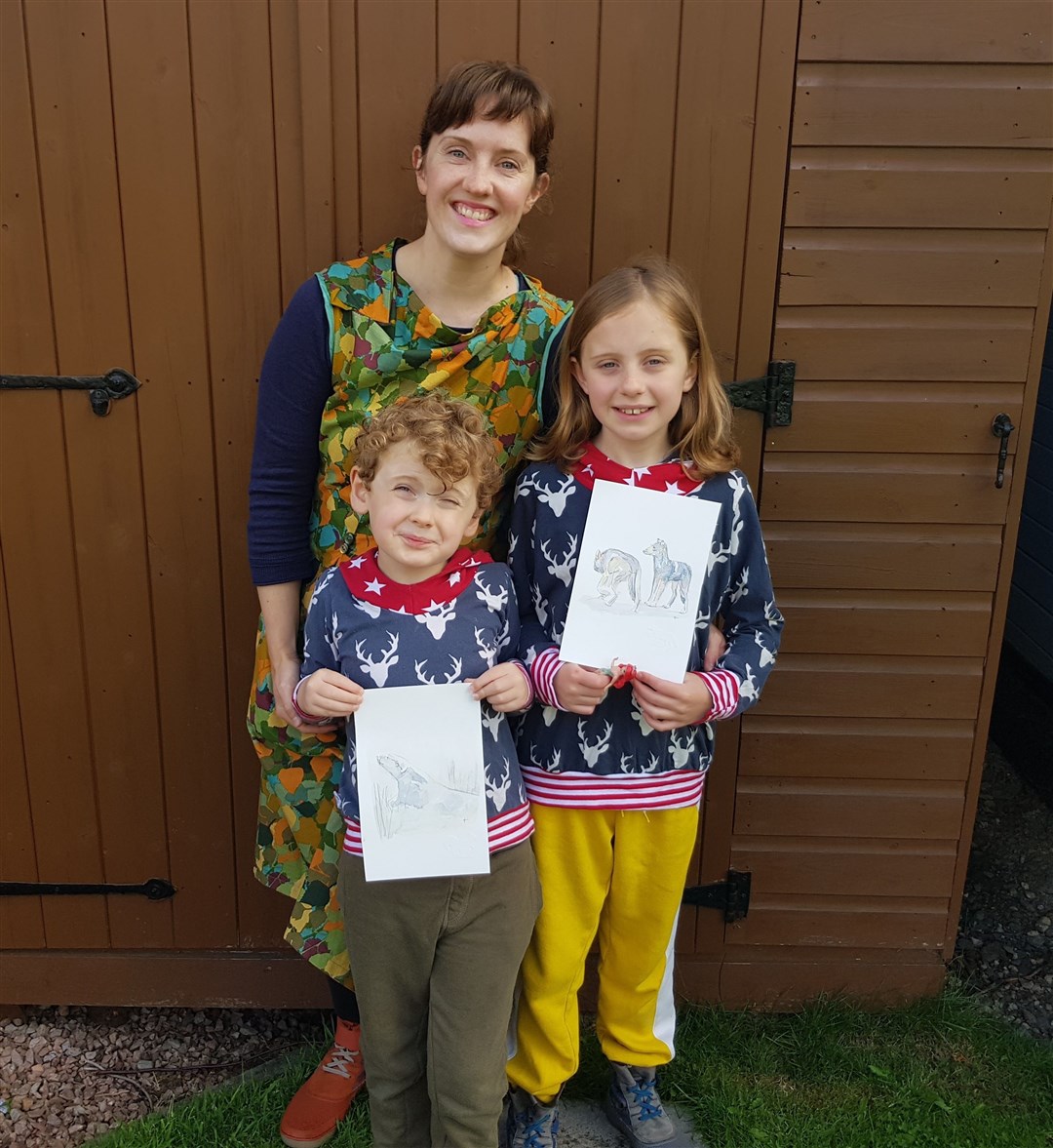 Mairi and children Eva and Alex show off the excellent watercolours of a polar bear and wolves.