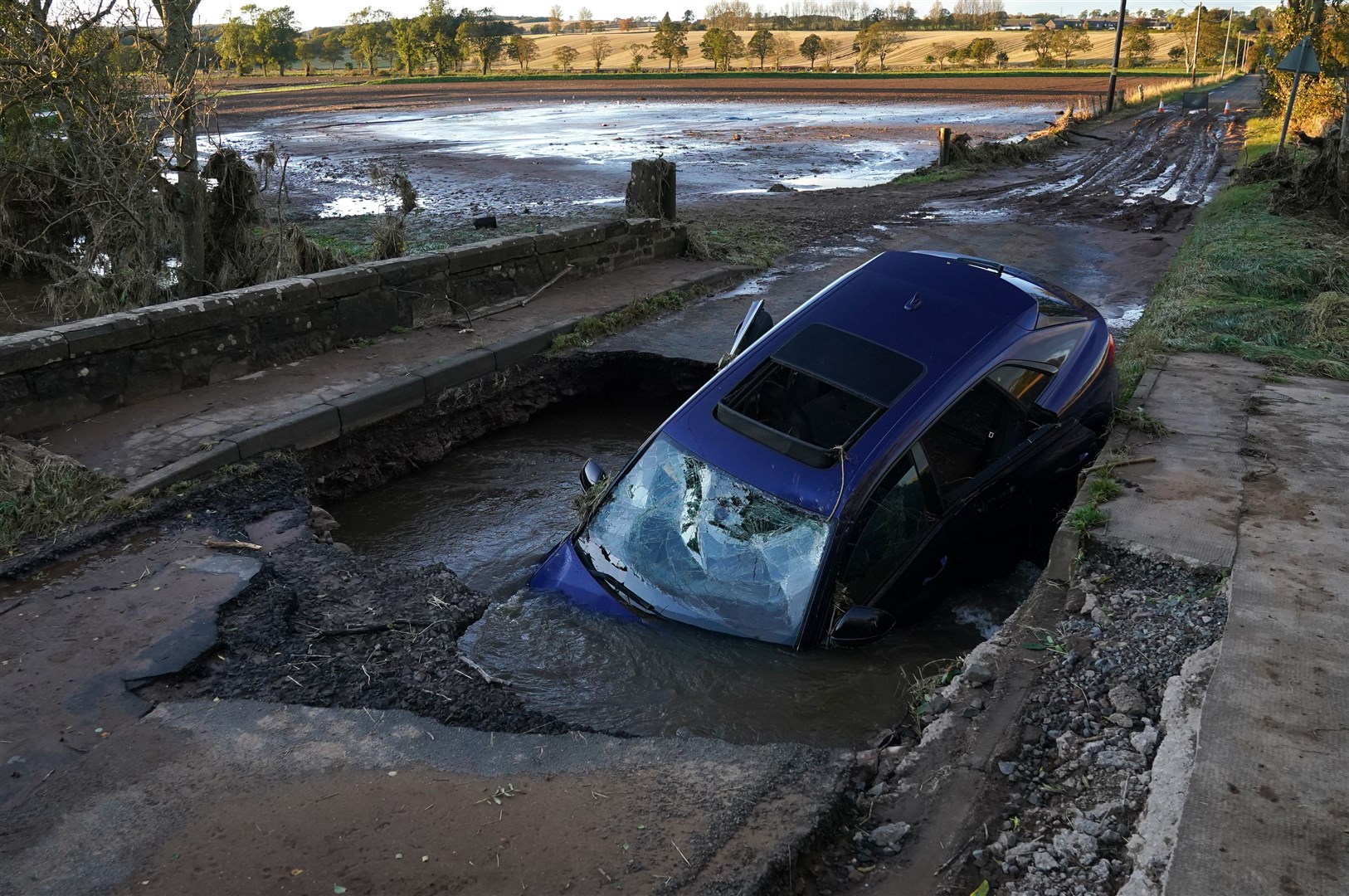 A car is seen on a bridge washed away near Dundee (Andrew Milligan/PA)