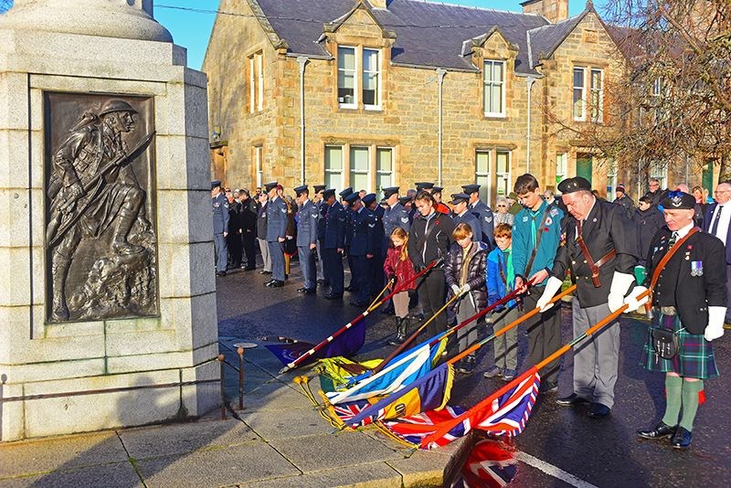 The colours are bowed in salute at Grantown War Memorial