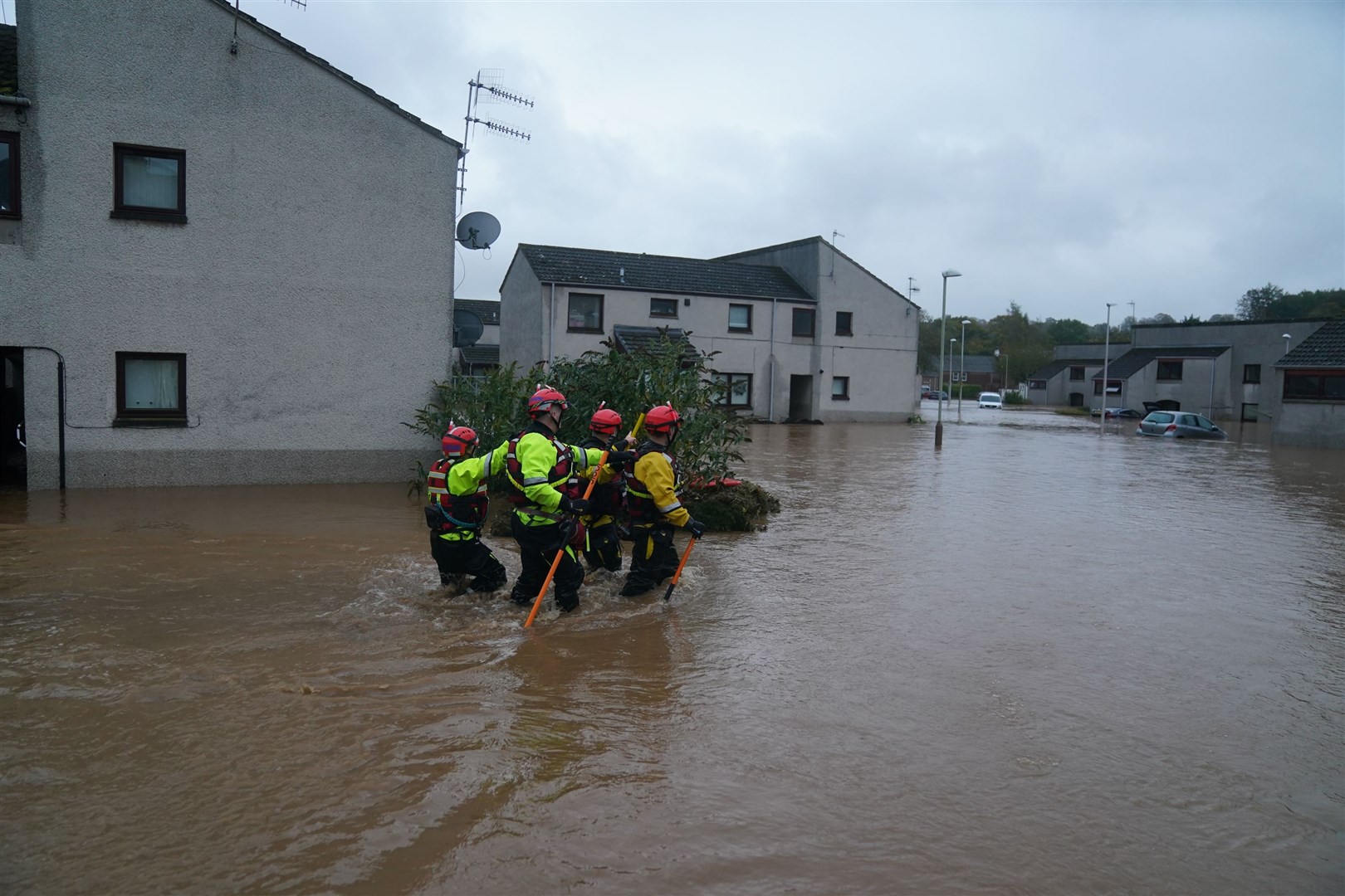 Emergency workers wade through flood water in Brechin as Storm Babet batters the country (Andrew Milligan/PA)