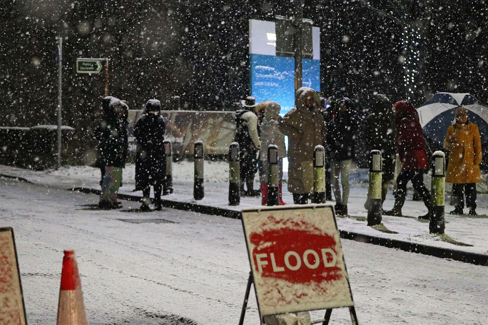People cross a bridge over the River Mersey as snow falls in East Didsbury (Peter Byrne/PA)