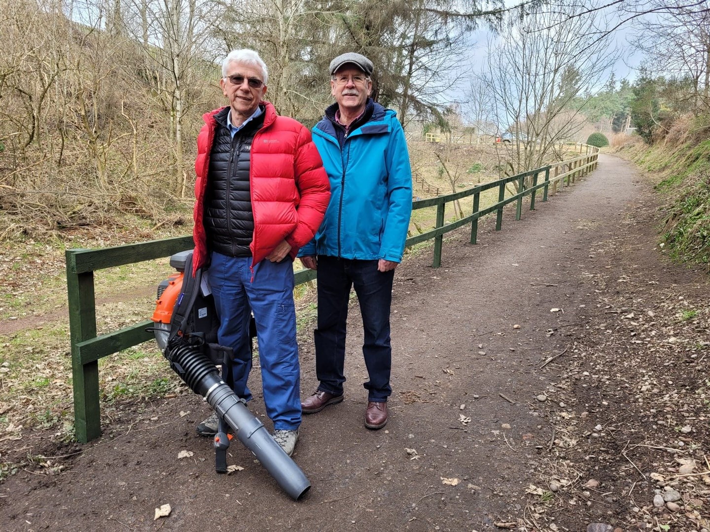 Dava Way Association secretary Malcolm Campbell and chairman Neil Sinclair with their new leaf blower at the new fence on Mannachie Avenue in Forres.