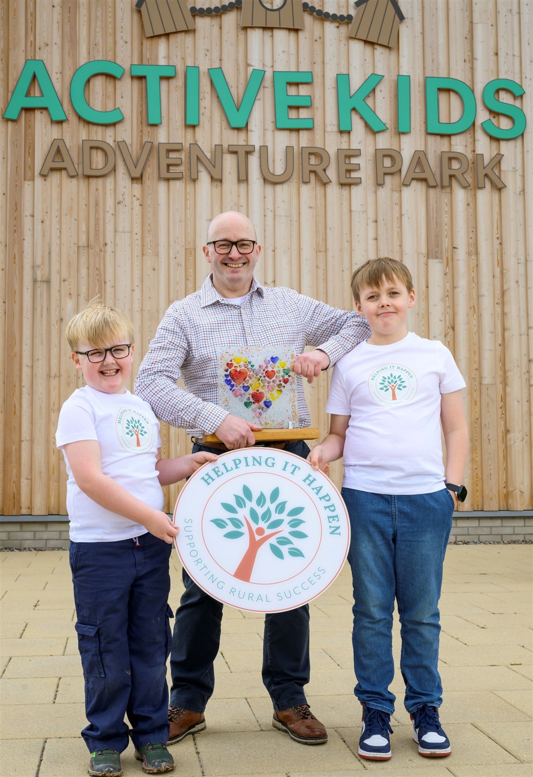 Rowland Thomson (Active Kids) is helped by Angus and Charlie to launch the 2024 awards