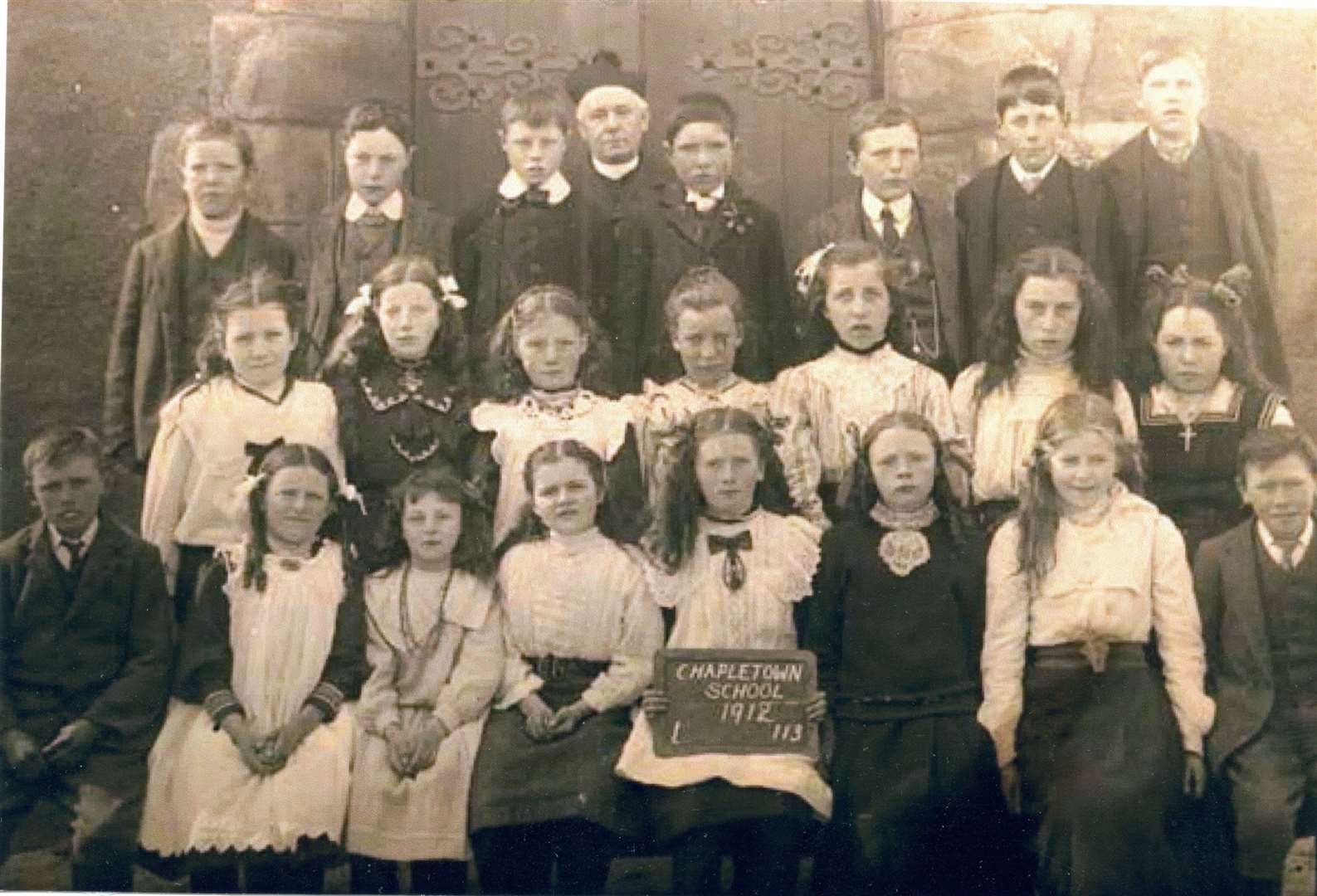 Chapeltown School pupils, 1912, in front of the Chapel at Chapeltown, with priest. Photo: M Hogg / Tomintoul & Glenlivet Digital Archive