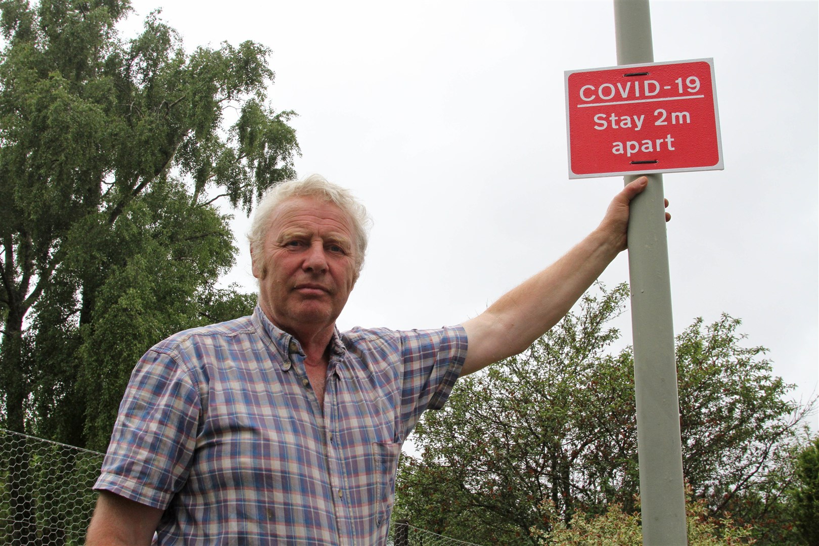 Nethy Bridge community leader John Kirk with one of the new signs in the village.