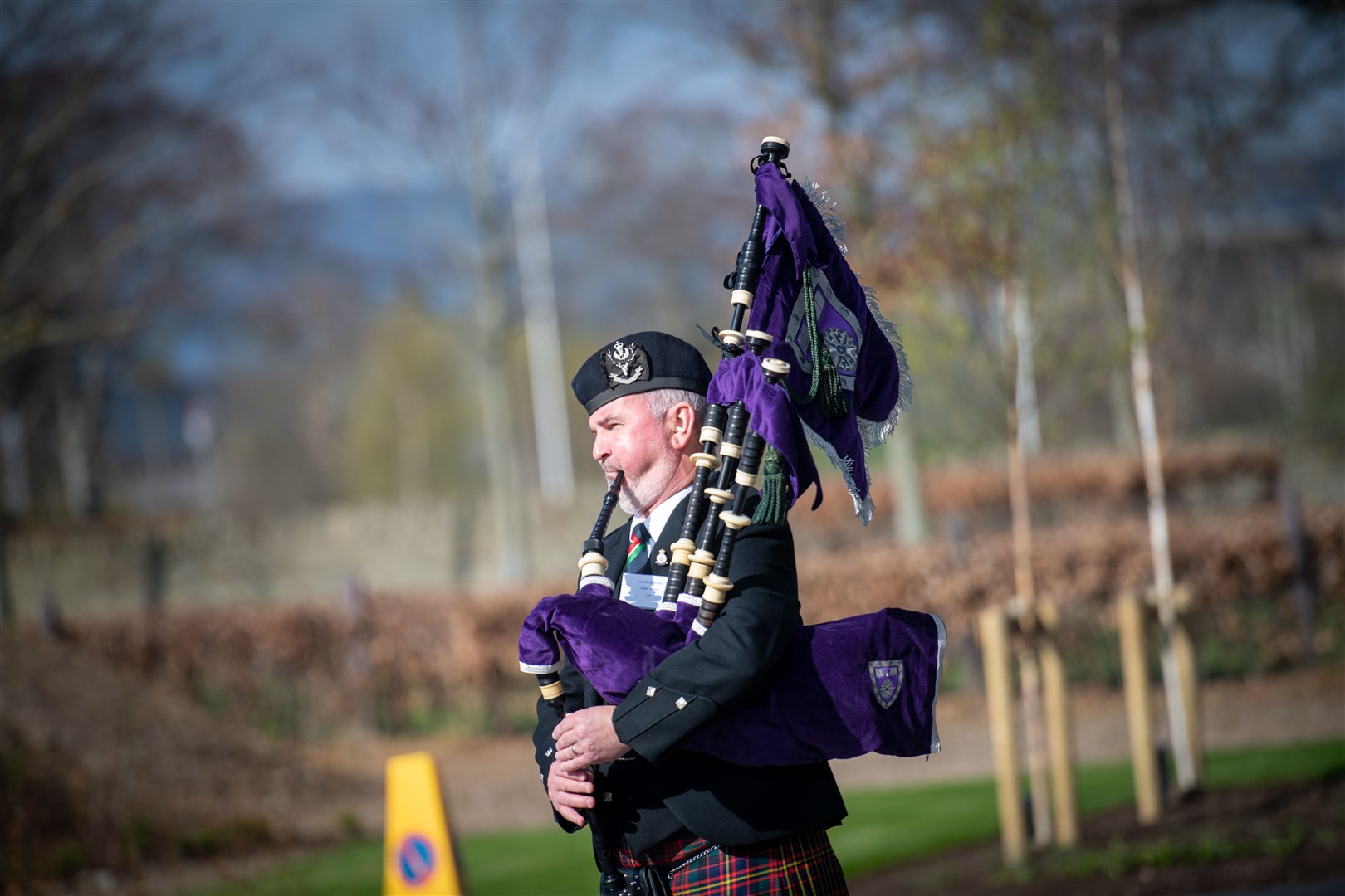 A piper greets the royal visitor.