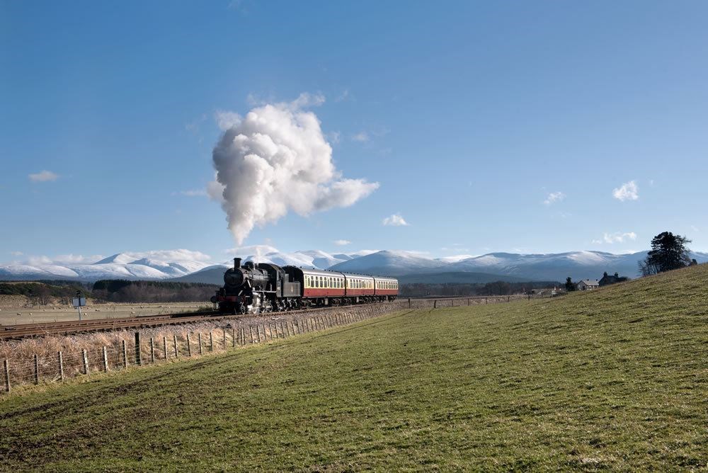 One of the steam railway's festive services on the way to Broomhill with the snowcapped Cairngorms in the background.