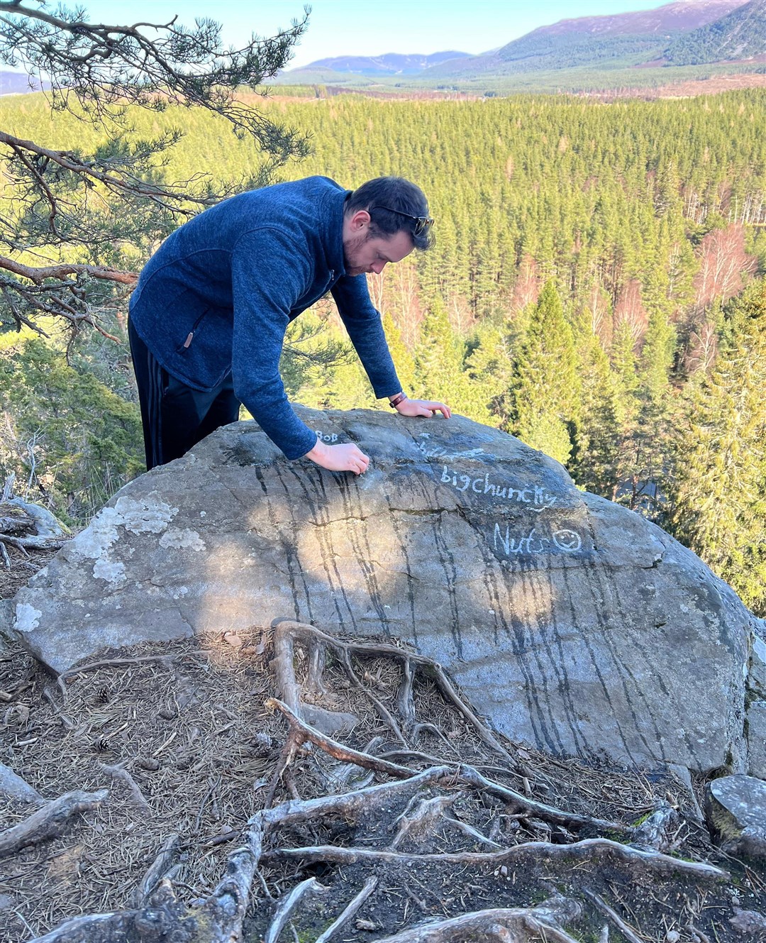 James Stevens removes the names from the rock as best he can. Picture: James Stevens.