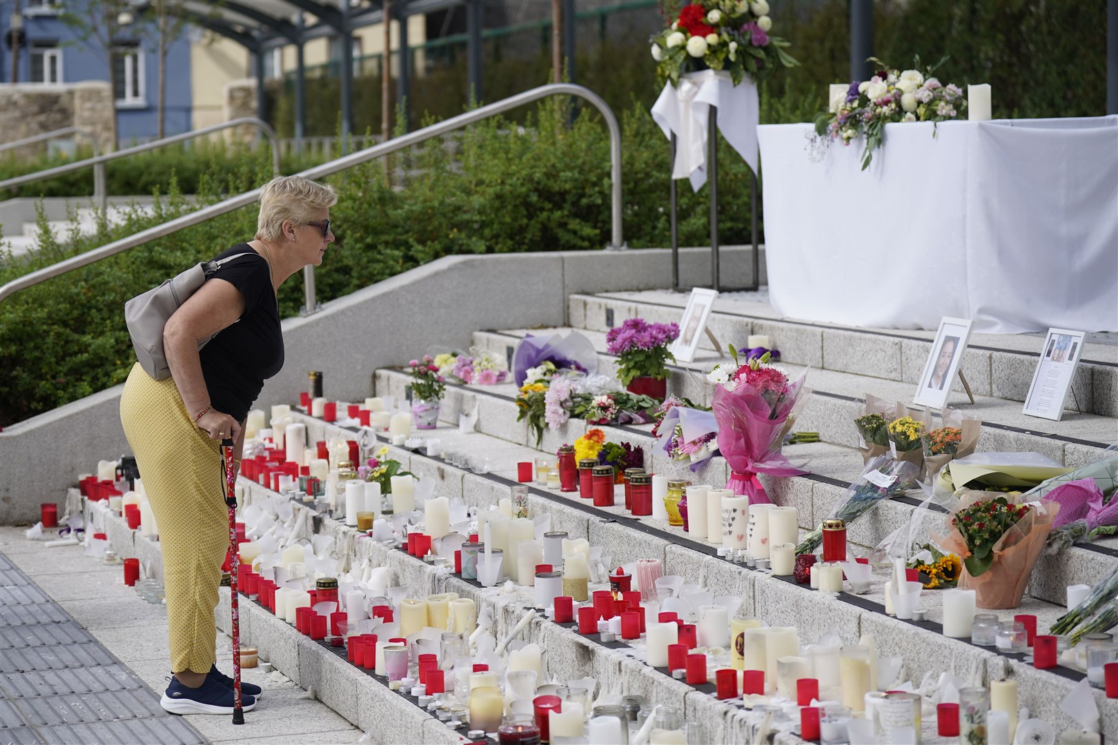 People continue to leave and look at tributes at Kickham Plaza, Co Tipperary (Niall Carson/PA)