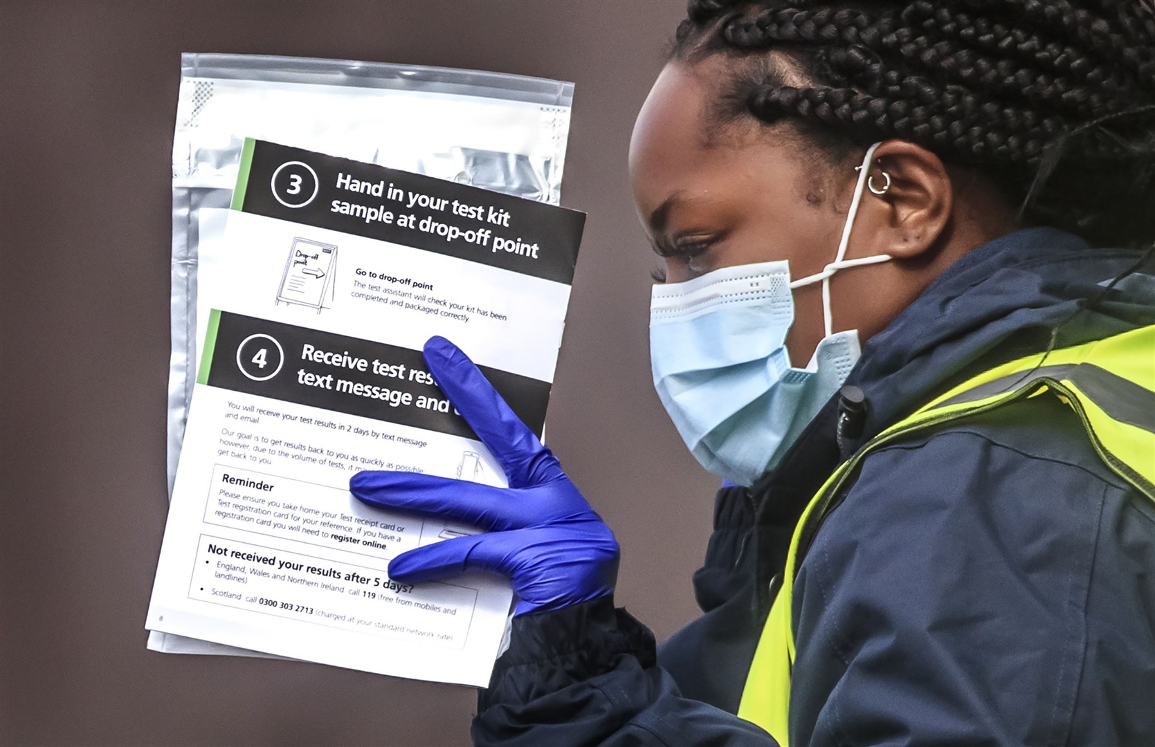 Staff hand out self-test kits at a testing centre in Bolton (Danny Lawson/PA)