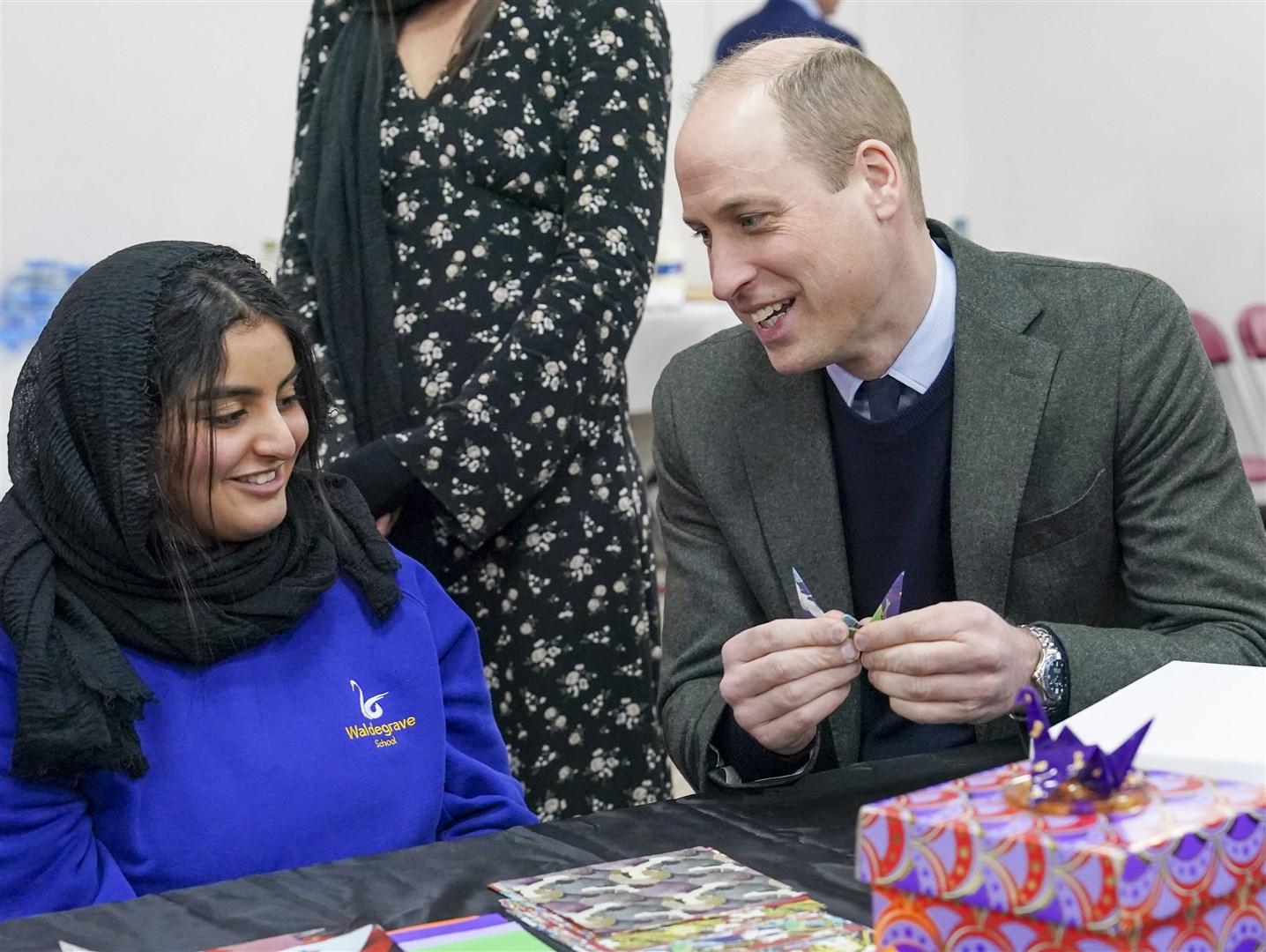 The Prince of Wales makes an origami crane with Lina Alkutubi during a visit to the Hayes Muslim Centre (Arthur Edwards/The Sun/PA)