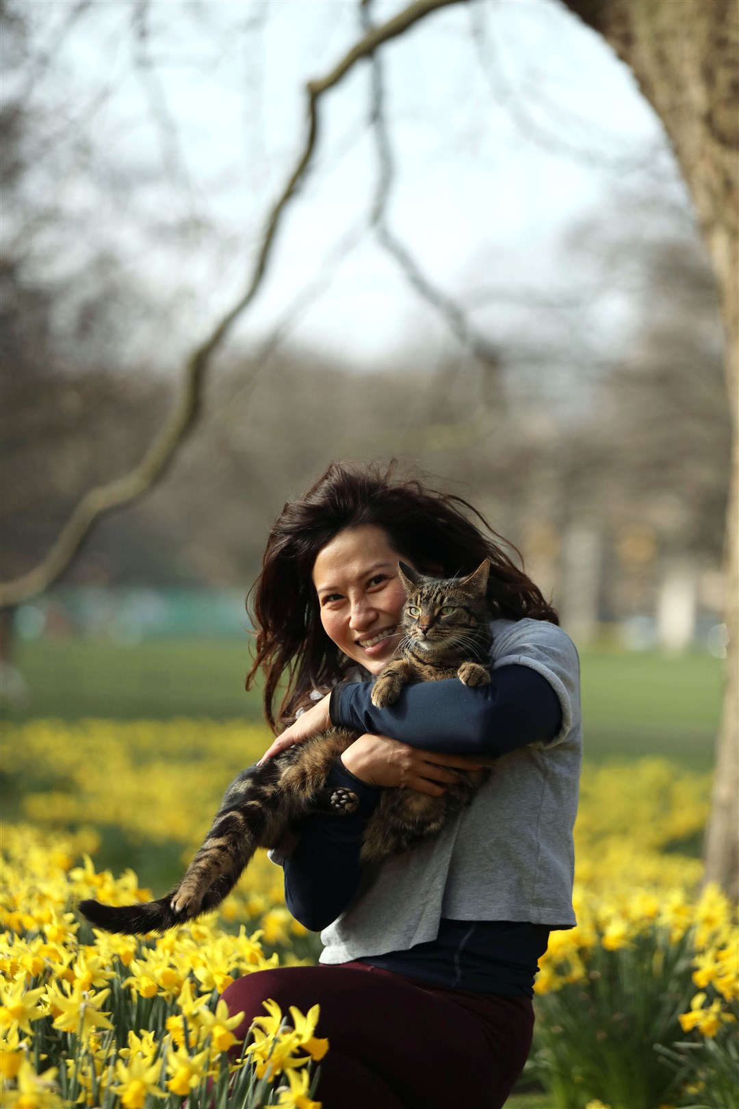 Serena with her cat Chummy among the daffodils in London’s St James’s Park (Luciana Guerra/PA)